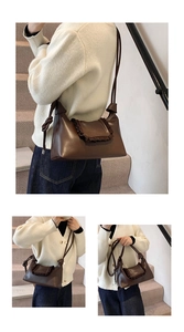 Detail view of dark brown leather shoulder bag featuring unique ruffled drawstring pleats