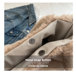 Detail view of the metal magnetic clasp on a plush tote bag with faux fur texture
