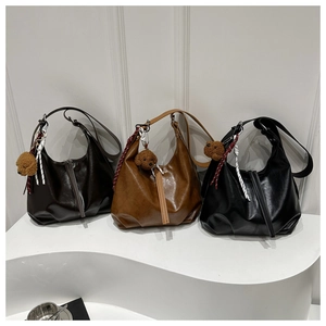 Trois sacs hobo minimalistes en cuir marron et noir avec des breloques ours en peluche