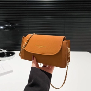 Sac bandoulière en cuir marron caramel avec chaîne dorée et rabat de style minimaliste