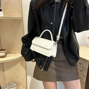 Elegante borsa a tracolla bianca con pannello a contrasto e patta strutturata su modella
