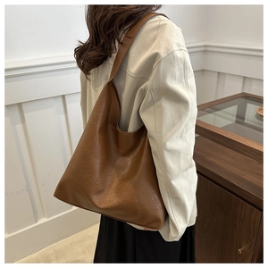 Brown faux leather tote bag with pebble texture styled for daily commute