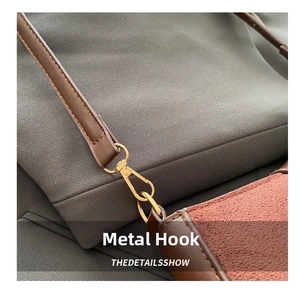Detail of gold metal hook and dark brown leather strap on textured shoulder bag