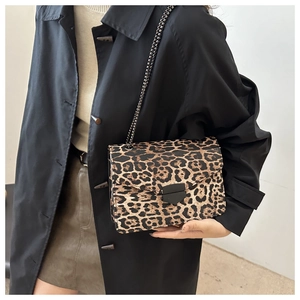 Detail view of the leopard print crossbody bag with metallic chain and black lock