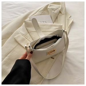 Detailed interior view of cream white leather underarm bag with gold buckle hardware