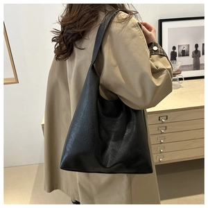 Detail of black faux leather tote bag with vintage wrinkled texture and large capacity