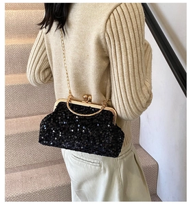 Gros plan d'un sac de soirée noir à paillettes avec cadre doré et bandoulière chaîne