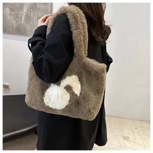 Brown plush tote bag with white rabbit pattern and fluffy handles shown on model