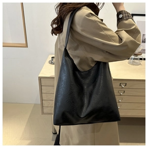 Detail view of a black large-capacity PU leather tote bag worn as a shoulder hobo bag