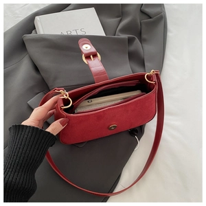 Detail of red matte suede shoulder bag interior with magnetic clasp and zipper pocket