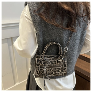 Modella con borsa a tracolla leopardata con dettaglio nappa e manico superiore