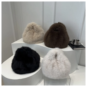 Group of plush faux fur handbags in beige, brown, black, and white on minimal stands