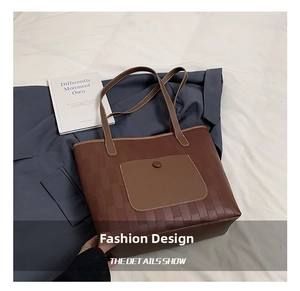 Close-up of brown woven texture tote bag featuring a front flap pocket with buckle detail