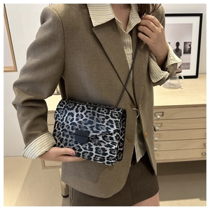 Close-up of leopard print crossbody bag with metal chain strap and black square buckle