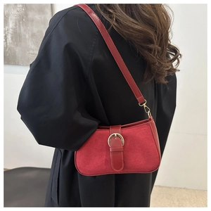 Detail of red vintage underarm bag featuring suede-leather stitching and gold ring buckle