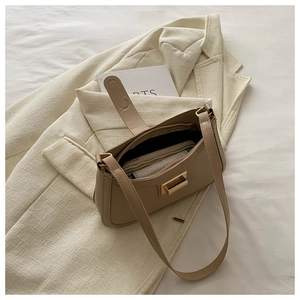 Top view of beige vintage baguette bag with gold buckle and spacious inner storage