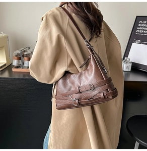 Detail of vintage brown motor bag with triple buckle straps and oil wax leather texture