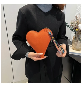 Détail du sac à main orange en forme de cœur avec cuir grainé et sangle LOVE