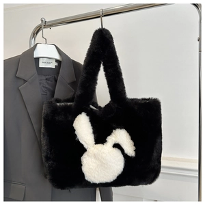 Detail of black faux fur tote bag featuring a white rabbit silhouette and fluffy handles