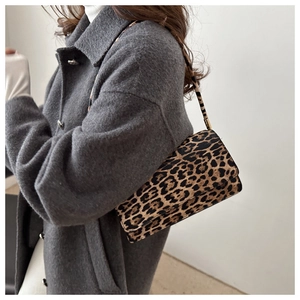 Leopard print crossbody bag side view styled with a grey wool coat on the shoulder