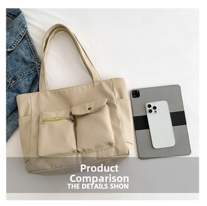 Detail of beige nylon tote bag featuring front zipper pocket and snap button flap pocket