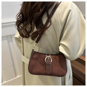 Detail of vintage matte suede underarm bag with leather strap and golden buckle