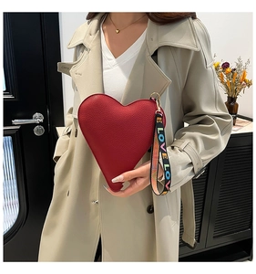 Close-up of heart-shaped handbag with red lychee texture and LOVE printed wrist strap
