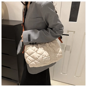 Quilted puffer tote bag in cream white with Fashion Bag tag shown on a shoulder