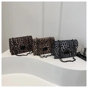 Detail view of leopard print crossbody bags in brown and grey with metal chain straps