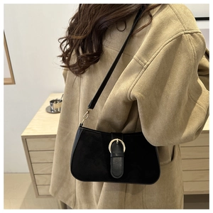 Detail of black semi-circle underarm bag with gold horseshoe buckle and matte texture