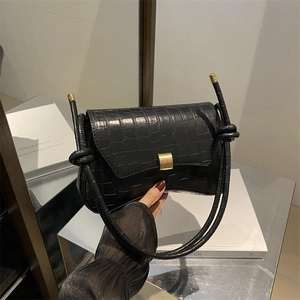 Classic black crocodile pattern baguette bag with a gold metal buckle and knotted strap