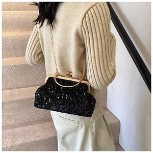 Détail du sac coquillage à paillettes noires avec bandoulière chaîne dorée porté