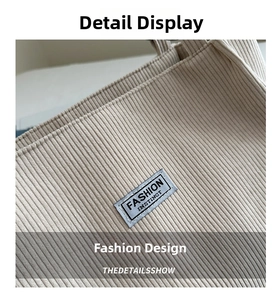 Macro shot of beige corduroy fabric texture and minimalist brand label on the tote bag