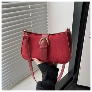 Close-up of red frosted suede underarm bag featuring a vintage large gold buckle detail