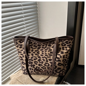Détail du sac cabas léopard avec poignées en cuir marron sous la lumière naturelle