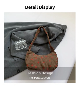 Detail of brown corduroy crescent bag with red strawberry print on grey blazer