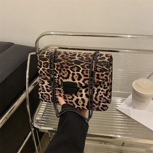 Chic leopard print crossbody bag with black metal chain strap and flap closure