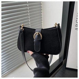 Detail of black matte suede and leather shoulder bag with golden buckle and strap