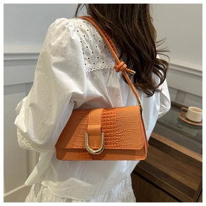 Detail of orange stone pattern shoulder bag with a gold U-shaped metal decorative buckle
