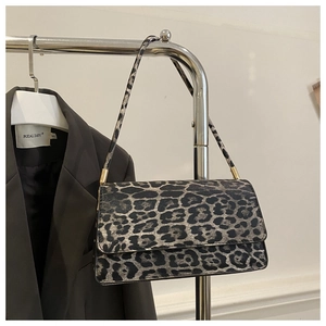 Close-up of leopard print texture and gold hardware on minimalist underarm bag