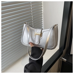 Detail of silver metallic baguette bag featuring a gold rectangle buckle and smooth PU finish