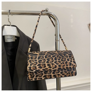 Detailed close-up of a leopard print flap shoulder bag with textured finish and slim strap