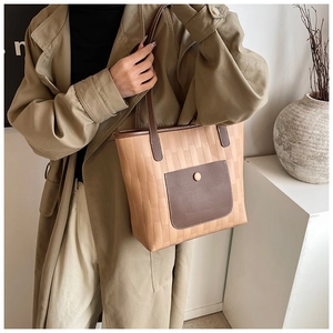 Detail of woven texture PU leather tote bag with brown pocket and slim shoulder strap