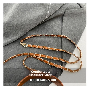 Detail of brown leather and gold chain shoulder strap with metal lobster clasp