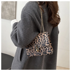 Dettaglio della borsa leopardata con catena dorata indossata su cappotto grigio