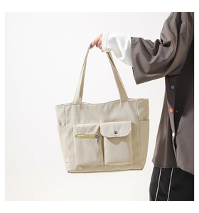 Detail view of large nylon tote bag with functional outer pockets and double handles