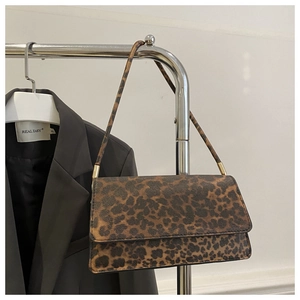 Detail view of leopard print shoulder bag with gold hardware and slim crossbody strap