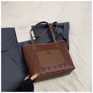 Close-up of woven leather texture and brown pocket on large minimalist tote bag