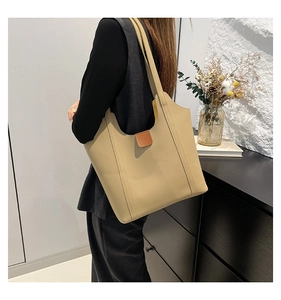 Chic beige tote bag with brown leather details shown in a stylish home setting