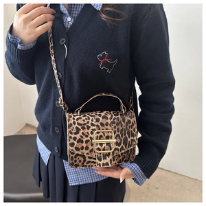 Détail d'un sac à bandoulière léopard avec boucle métallique dorée et rabat élégant